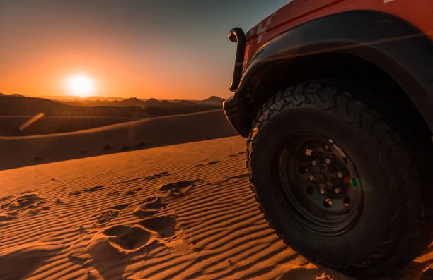 Sunset in the desert with details of a 4x4 vehicle