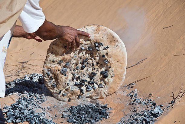 Tuareg man preparing the traditional bread in the desert, South Tunisia